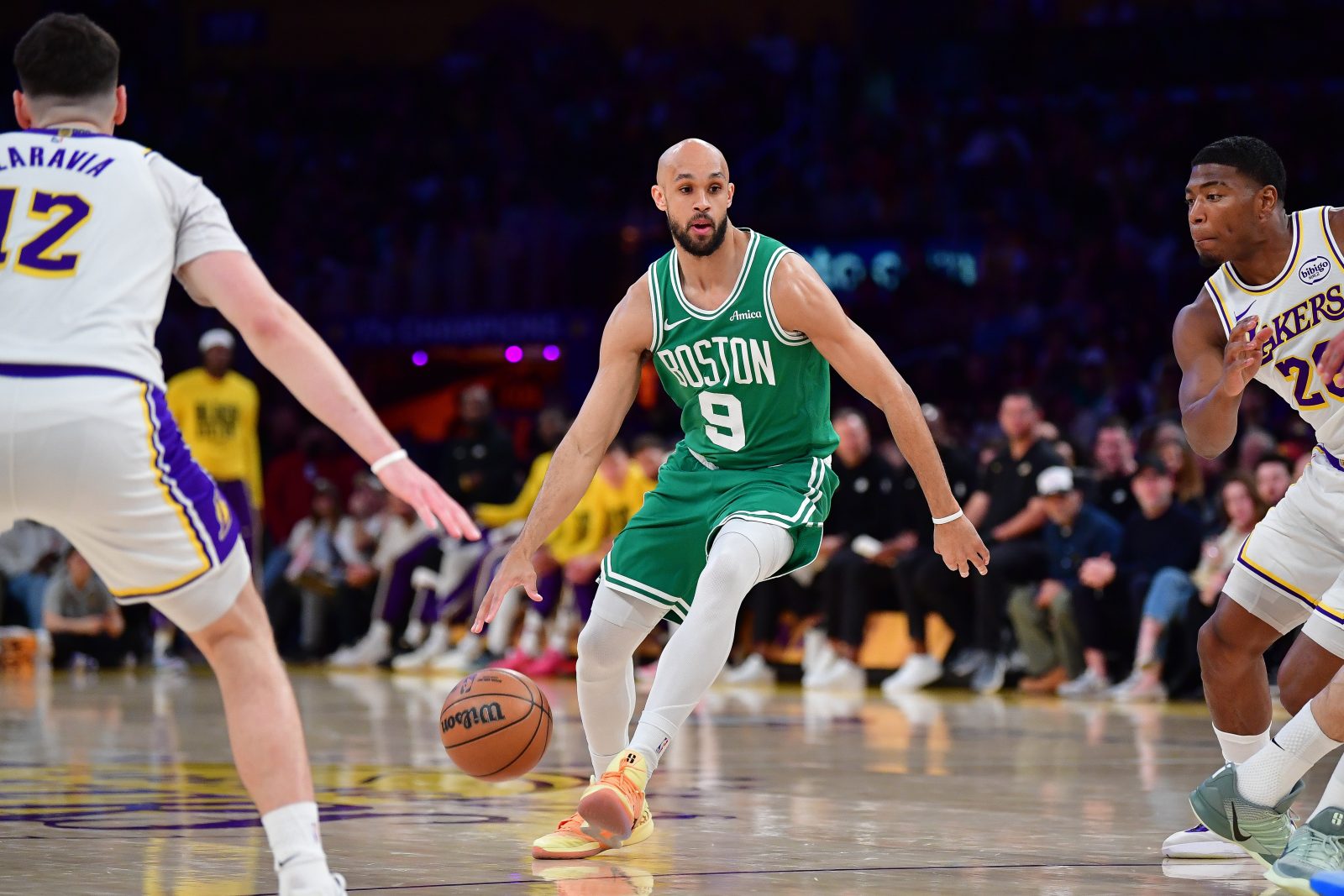 Feb 22, 2026; Los Angeles, California, USA; Boston Celtics guard Derrick White (9) moves the ball against Los Angeles Lakers forward Jake LaRavia (12) and forward Rui Hachimura (28) during the first half at Crypto.com Arena. Mandatory Credit: